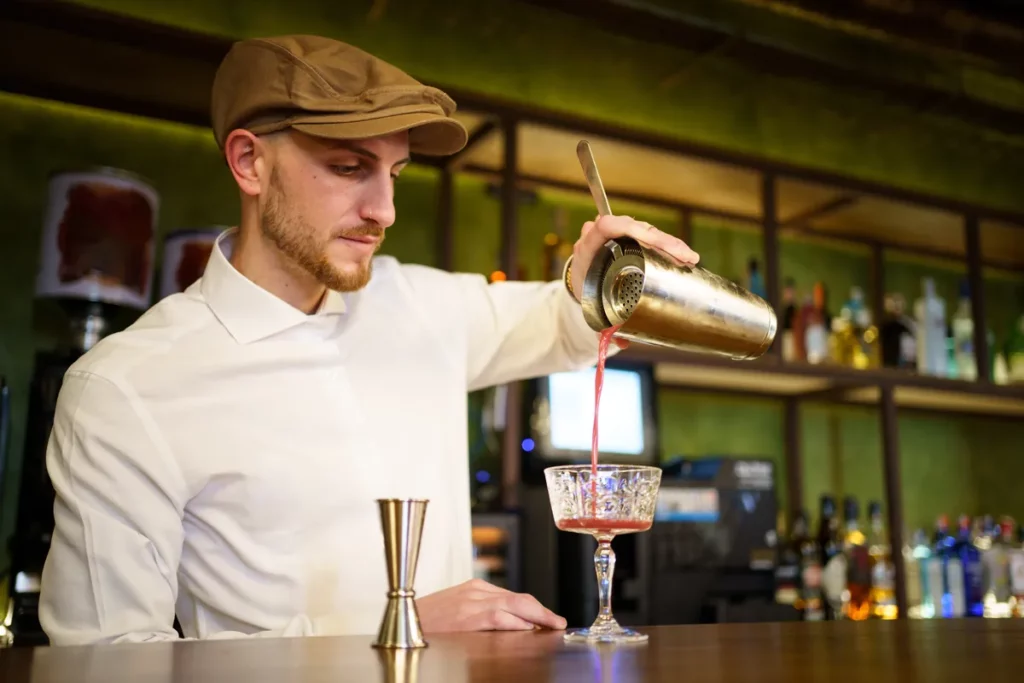 Un prof mixologue qui sert un cocktail en atelier